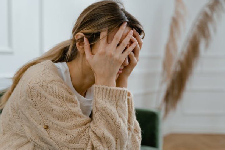 A woman holding her head in discomfort from a headache