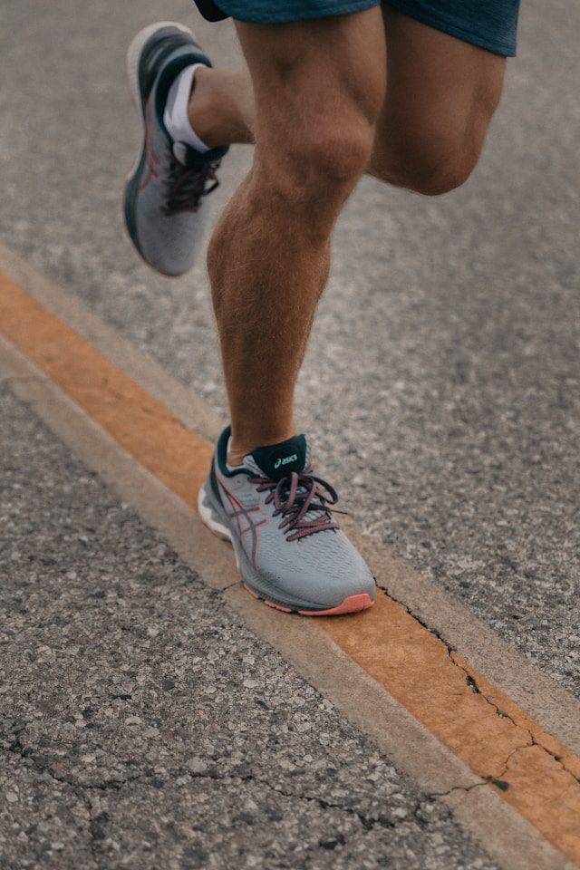 A runner mid-stride in running shoes — foot mechanics affect everything above them.